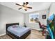 A comfy bedroom featuring a ceiling fan, window shutters, desk, and personal touches at 18822 E Flintlock Dr, Queen Creek, AZ 85142