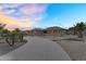 Beautiful home with a long circular driveway and desert landscaping at sunset at 18822 E Flintlock Dr, Queen Creek, AZ 85142