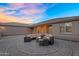 Outdoor patio featuring a cozy fire pit with wrap around seating, creating an inviting ambiance for gatherings at 18822 E Flintlock Dr, Queen Creek, AZ 85142