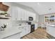Modern kitchen with white cabinets, black appliances, and adjacent breakfast nook at 18822 E Flintlock Dr, Queen Creek, AZ 85142
