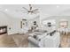 Open-concept living area featuring a cozy fireplace, modern ceiling fan, and easy access to kitchen at 18822 E Flintlock Dr, Queen Creek, AZ 85142