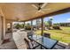 Covered patio offers serene views of the pool, lush greenery, and manicured backyard at 18822 E Flintlock Dr, Queen Creek, AZ 85142