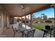 Spacious covered patio with ceiling fans and outdoor furniture overlooking the lush backyard at 18822 E Flintlock Dr, Queen Creek, AZ 85142