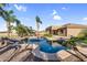 Backyard pool surrounded by palm trees offering a private oasis for relaxation and entertainment at 18822 E Flintlock Dr, Queen Creek, AZ 85142
