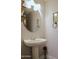 This powder room features a pedestal sink, round mirror and neutral walls at 1950 W Park Pl, Chandler, AZ 85224