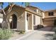 Tan stucco home featuring an arched front porch, a tile roof, and desert landscaping at 1950 W Park Pl, Chandler, AZ 85224