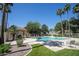 Community pool with a deck, seating, landscaping, and shade structures at 1950 W Park Pl, Chandler, AZ 85224