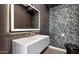 Modern bathroom featuring a floating vanity, stylish mirror, and textured wallpaper at 20274 N 76Th Way, Scottsdale, AZ 85255
