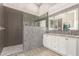 Beautiful bathroom featuring a tiled shower, glass door, and a double sink vanity with modern lighting at 20427 N 88Th Dr, Peoria, AZ 85382