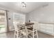 Bright breakfast nook with a wooden table, white chairs, and a view of the pool area at 20427 N 88Th Dr, Peoria, AZ 85382