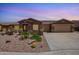 Charming single-story home with a three-car garage, desert landscaping, and front yard patio at 20427 N 88Th Dr, Peoria, AZ 85382