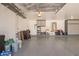 Bright garage featuring storage cabinets, epoxy flooring, sink, and water heater at 20427 N 88Th Dr, Peoria, AZ 85382