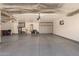 Spacious garage featuring a gray epoxy floor, built-in cabinets, and ample storage space at 20427 N 88Th Dr, Peoria, AZ 85382