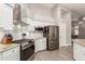 Updated kitchen features stainless steel appliances, granite countertops, and a stylish range hood at 20427 N 88Th Dr, Peoria, AZ 85382