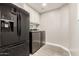 Laundry room featuring a refrigerator, washer and dryer at 20427 N 88Th Dr, Peoria, AZ 85382