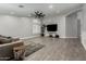 Spacious living room with wood-look floors, ceiling fan and ample natural light at 20427 N 88Th Dr, Peoria, AZ 85382