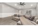 Cozy living room featuring wood-look floors, a plush sectional sofa, and wainscoting at 20427 N 88Th Dr, Peoria, AZ 85382