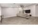 Spacious living room featuring wood-look floors, modern ceiling fan, and a media center at 20427 N 88Th Dr, Peoria, AZ 85382