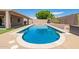 Sparkling pool with a spa, artificial turf, and mature desert landscaping at 20427 N 88Th Dr, Peoria, AZ 85382