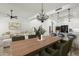 Elegant dining area with modern lighting, a wooden table, and a view into the living room at 20802 N Grayhawk Dr # 1123, Scottsdale, AZ 85255