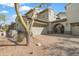 Inviting home exterior featuring desert landscaping, a two-car garage, and an arched entryway with gated access at 20802 N Grayhawk Dr # 1123, Scottsdale, AZ 85255
