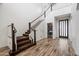 Grand foyer featuring a staircase, beautiful wood floors, and a powder room with designer wallpaper at 20802 N Grayhawk Dr # 1123, Scottsdale, AZ 85255
