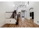Open foyer with a staircase, chandelier, beautiful wood floors, and view to powder room and kitchen at 20802 N Grayhawk Dr # 1123, Scottsdale, AZ 85255