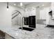 Stylish kitchen features sleek black appliances, white cabinetry, and a granite countertop island at 20802 N Grayhawk Dr # 1123, Scottsdale, AZ 85255