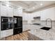 Modern kitchen featuring white cabinetry, granite countertops, and stainless steel appliances at 20802 N Grayhawk Dr # 1123, Scottsdale, AZ 85255
