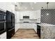 Modern kitchen features stylish black appliances, white cabinets, and a granite countertop at 20802 N Grayhawk Dr # 1123, Scottsdale, AZ 85255