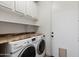 Functional laundry room features washer, dryer, countertops and built-in cabinets for storage at 20802 N Grayhawk Dr # 1123, Scottsdale, AZ 85255