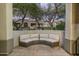 Inviting curved patio furniture offers outdoor relaxation, complemented by mature trees and nearby residential architecture at 20802 N Grayhawk Dr # 1123, Scottsdale, AZ 85255
