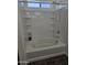 Bathtub with a shower head surrounded by white tile with storage at 20941 N Leona Blvd, Maricopa, AZ 85138