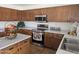 Well-lit kitchen with wood cabinets, tile floors, stainless steel appliances, and a kitchen island at 20941 N Leona Blvd, Maricopa, AZ 85138