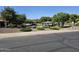 View of a community park with green grass, mature trees, landscaping, picnic pavilion, and play equipment at 20941 N Leona Blvd, Maricopa, AZ 85138