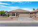 Charming single-story home with a desert landscape, tile roof, and attached two-car garage on a sunny day at 22576 N Davis Way, Maricopa, AZ 85138