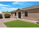 Charming single-story home boasts a tidy front yard, flower bushes, and neutral-tone facade at 22576 N Davis Way, Maricopa, AZ 85138
