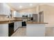 Bright kitchen features stainless steel appliances, white cabinets, and kitchen island at 22576 N Davis Way, Maricopa, AZ 85138