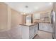 Bright kitchen features a functional island, stainless appliances, and modern tile floors at 22576 N Davis Way, Maricopa, AZ 85138