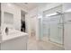 Bright bathroom with a glass-enclosed shower, double sinks, white cabinets, and a walk-in closet at 23937 W Hopi St, Buckeye, AZ 85326