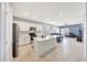 Open kitchen with white cabinets, stainless steel appliances, island, and adjoining living room at 23937 W Hopi St, Buckeye, AZ 85326
