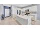 Bright kitchen features white cabinetry, stainless appliances and a large island with a sink and breakfast bar at 23937 W Hopi St, Buckeye, AZ 85326