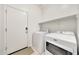 Bright laundry room with white appliances and door access at 23937 W Hopi St, Buckeye, AZ 85326