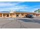 Exterior of the clubhouse with solar panels, ample parking, handicap access, and inviting entrance for community gatherings at 2400 E Baseline Ave # 228, Apache Junction, AZ 85119