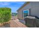 Exterior angle of a house with a covered grill, paved walkway, and desert landscaping at 2400 E Baseline Ave # 228, Apache Junction, AZ 85119