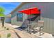 Cozy outdoor setting featuring chairs and a table under a red umbrella, with a neat desert landscape at 2400 E Baseline Ave # 228, Apache Junction, AZ 85119
