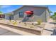 Inviting outdoor seating area with a red umbrella, surrounded by a neatly landscaped desert garden at 2400 E Baseline Ave # 228, Apache Junction, AZ 85119