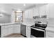 Bright kitchen featuring white cabinets, stainless appliances, and mosaic backsplash at 2400 E Baseline Ave # 228, Apache Junction, AZ 85119