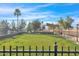 Serene park with lush green grass, palm trees, shaded seating area, and a fenced perimeter for resident relaxation at 2400 E Baseline Ave # 228, Apache Junction, AZ 85119