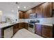 Modern kitchen with stainless steel appliances, tiled backsplash, and dark cabinets at 2511 W Queen Creek Rd # 337, Chandler, AZ 85248